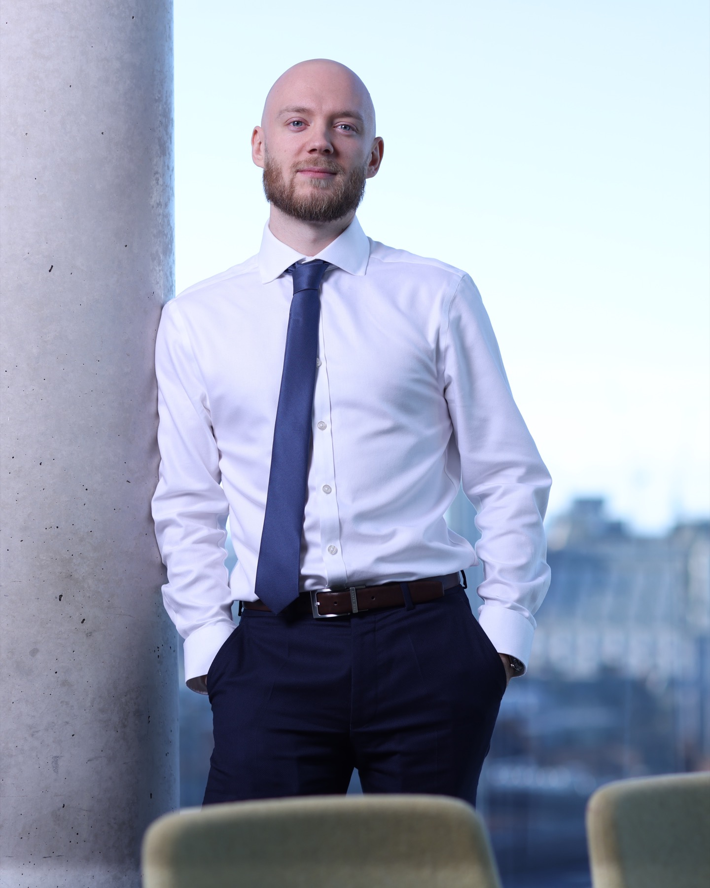 Anthony Hautin standing in a white shirt and navy tie